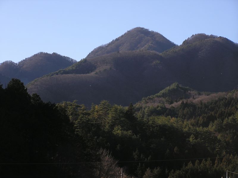 県道712号から望む鶴ヶ鳥屋山（中央）は、鶴が飛ぶ姿に似ていなくもない