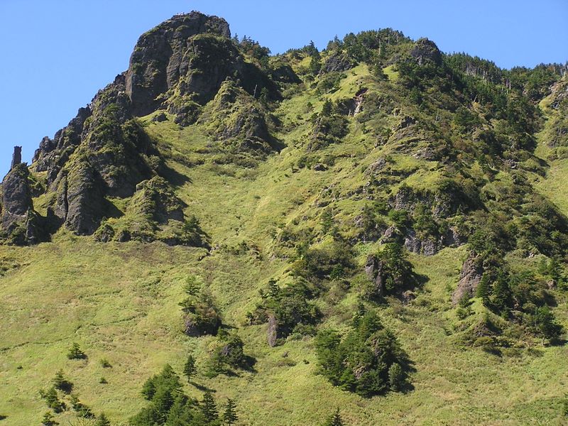 浅間山 -- 草すべりをトーミの頭（岩峰）に向かって登る人々が見える